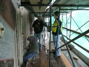 On the scaffold, behind the curtain, preparing to remove the stained glass panels.  Photo, the author.
